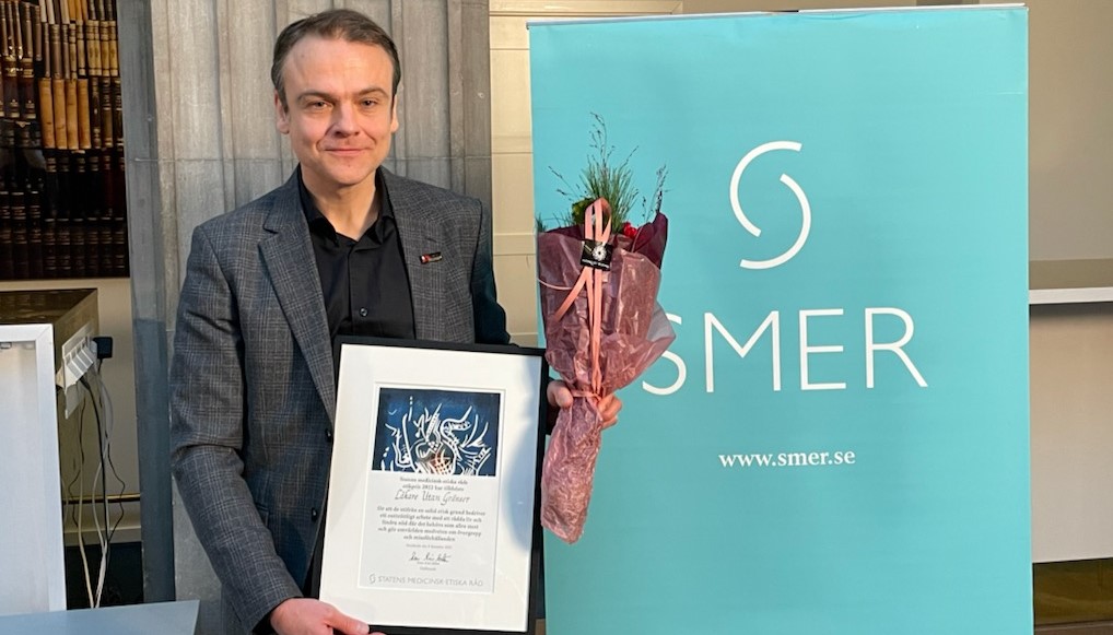 Ordföranden för Läkare utan gränser i Sverige, Peter Moberger, med diplom och blombukett